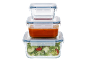 Recipientes de vidro empilhados para armazenamento de alimentos, um com molho de tomate, outro com salada.