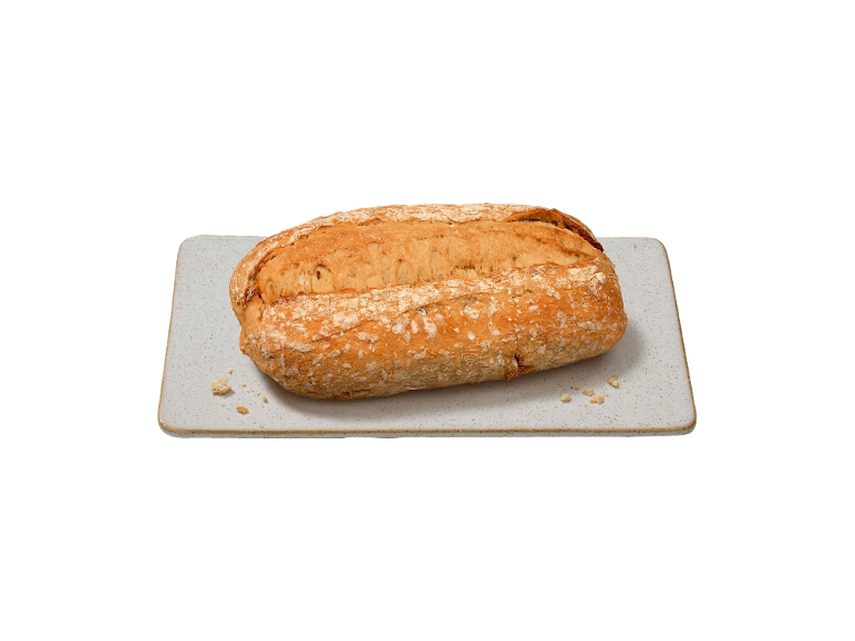 Um pão numa tábua de corte retangular.