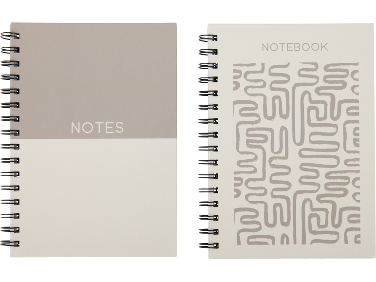 Dois cadernos em espiral, um com 'NOTES' numa capa de dois tons, o outro com 'NOTEBOOK' e um padrão de labirinto.