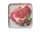 Bife de entrecôte cru num prato, guarnecido com cebola roxa e salsa.