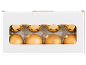 Bolas de Natal douradas numa caixa de cartão branca.