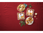 Bolachas de Natal Favorina com sabores a coco e amêndoa num fundo vermelho festivo