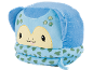 Peluche azul com rosto amarelo, olhos pretos e manchas verdes, com textura de escamas.