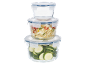 Pilha de recipientes de vidro para alimentos com tampas azuis, cheios de curgete e bulgur.