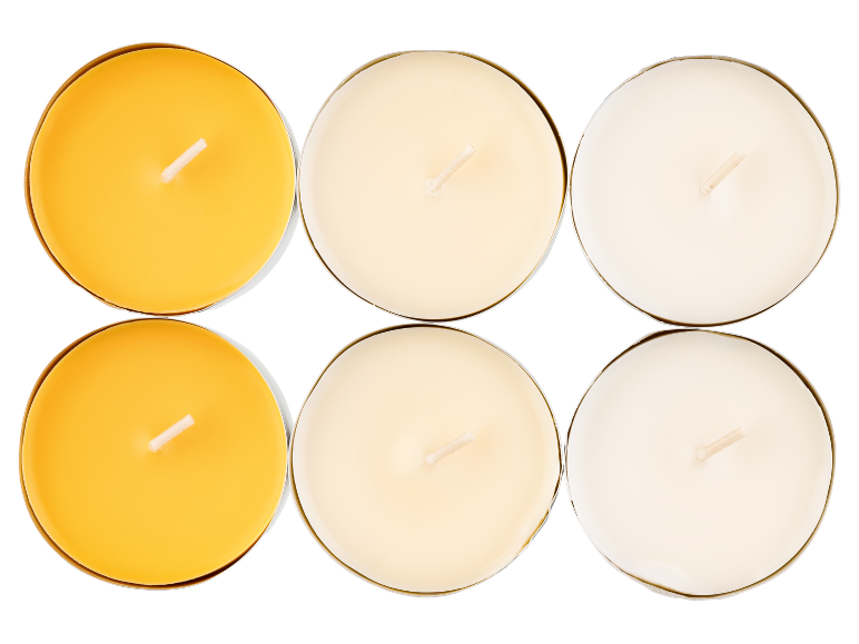Seis velas tealight, duas amarelas, duas creme e duas brancas, sobre fundo preto.