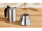 Máquina de café com café moído sobre uma mesa de madeira.