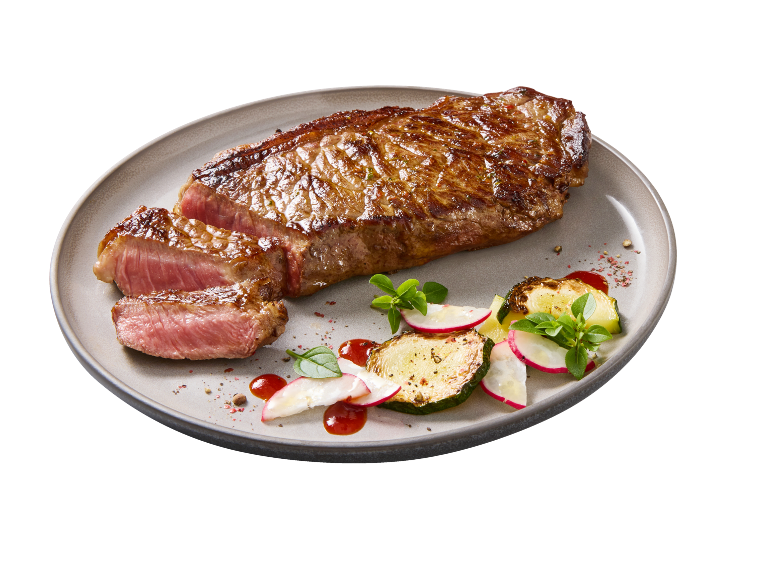 Bife de vaca suculento no ponto com acompanhamento de legumes num prato.