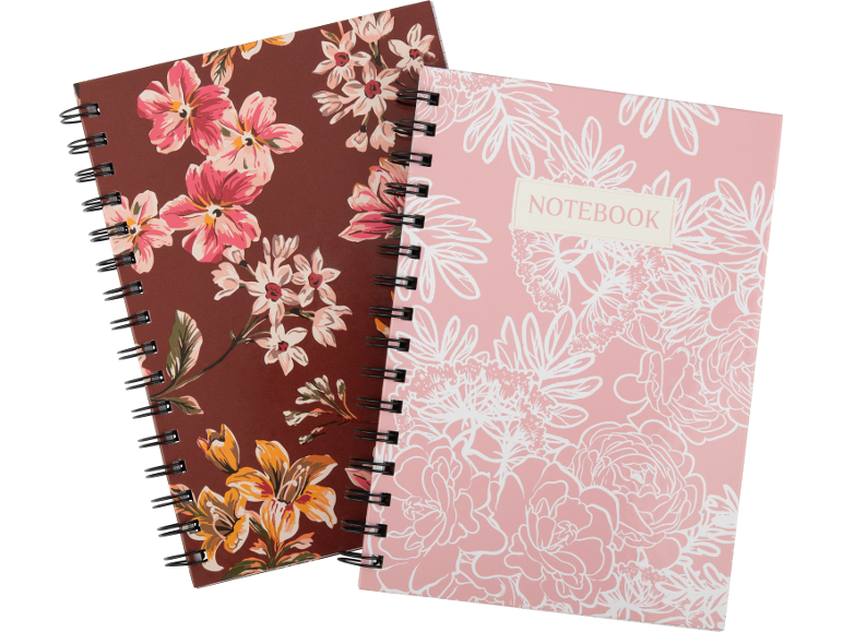 Dois cadernos de argolas, um castanho com padrão floral, outro rosa com o texto 'NOTEBOOK'.