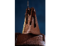 Bolo de chocolate com calda de chocolate escuro, com uma fatia cortada.