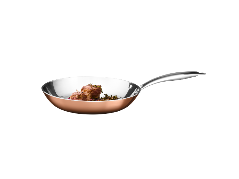 Frigideira de cobre com filé de carne e ervas.