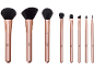Conjunto de oito pincéis de maquilhagem em ouro rosa, incluindo pincéis para pó, blush e olhos.