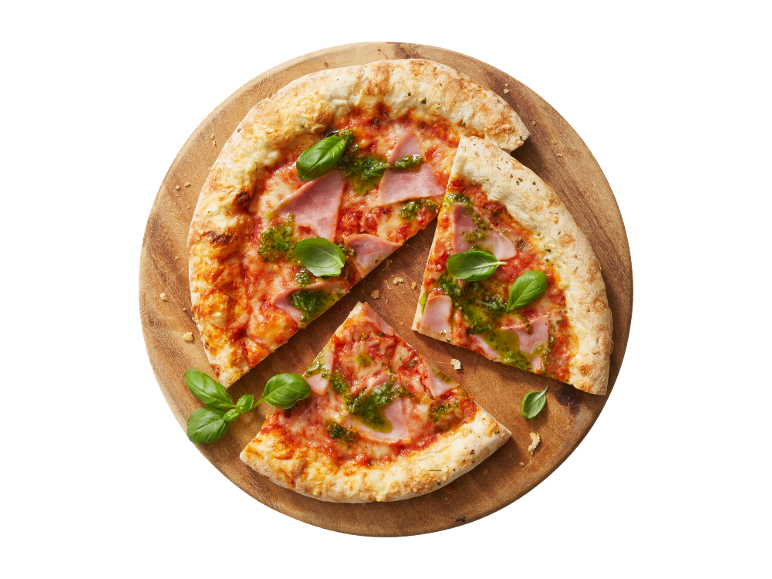 Pizza com fiambre, pesto e manjericão numa tábua de madeira, com duas fatias ao lado.