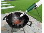 Mão segurando um acendedor elétrico de carvão sobre um churrasco com brasas.