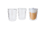 Conjunto de três copos de vidro de parede dupla, um deles cheio de café com espuma de leite