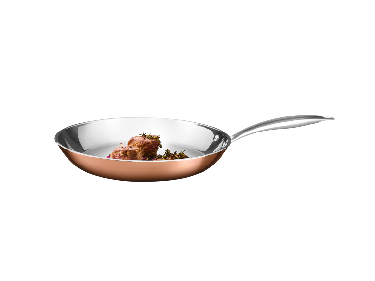 Frigideira de cobre com carne e ervas