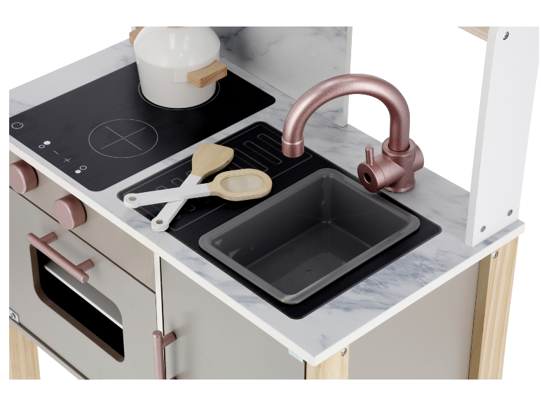 Cozinha de brincar de madeira com bancada de mármore, detalhes em ouro rosa, placa, lava-loiça e utensílios.