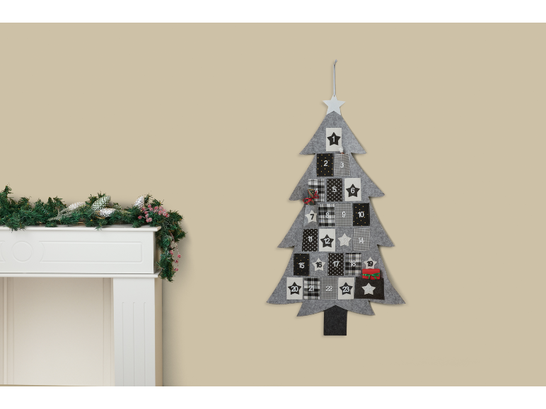 Calendário do Advento em forma de árvore de Natal com bolsos e lareira decorada com guirlanda.
