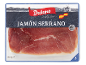 Embalagem de presunto Serrano fatiado, com bandeira espanhola e moinhos de vento ao fundo.