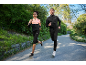 Homem e mulher a correr num parque com casacos desportivos e leggings.
