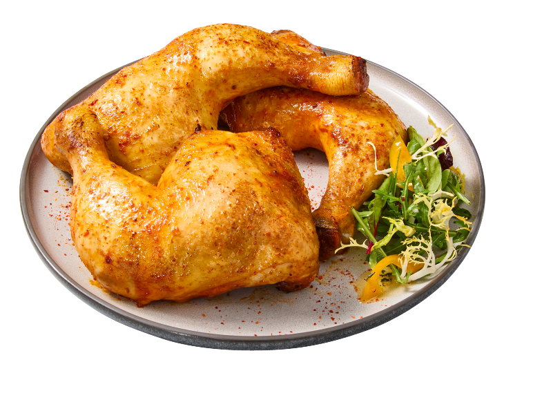 Coxas de frango assadas com salada num prato.