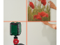 Nível a laser projetando linhas numa parede onde um quadro está a ser pendurado.