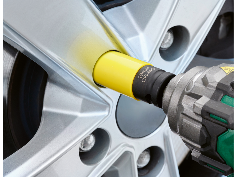Chave de impacto com um adaptador amarelo de 19mm CR-MO numa roda de carro.