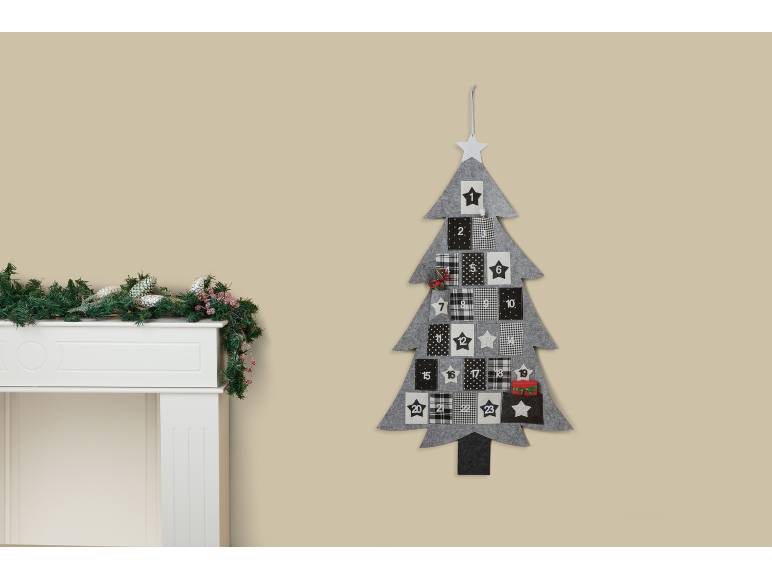 Calendário do advento de Natal em forma de árvore com uma lareira branca decorada com guirlanda.