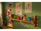 Seis brinquedos de monstros coloridos numa prateleira de madeira num quarto de criança com desenhos de Natal.