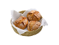 Três pães crocantes numa cesta de pão com um pano branco.