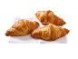 Três croissants dourados sobre um guardanapo branco.