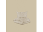 Conjunto de roupa de cama de algodão bege claro, com uma almofada e um edredão dobrado.