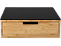 Suporte de monitor em bambu com gaveta e tampo de vidro preto.