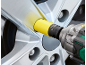 Chave de impacto com um adaptador amarelo de 19mm CR-MO numa roda de carro.