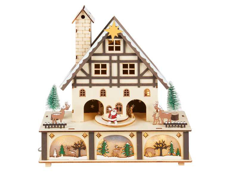 Casa de Natal de madeira com iluminação, figuras de Pai Natal e renas, e árvores de Natal.