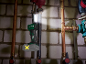 Luz de trabalho sem fio pendurada num tubo, iluminando uma parede de tijolos e canalização.