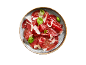 Carpaccio de carne com parmesão e manjericão num prato.