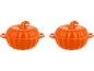 Duas panelas de cerâmica laranja em forma de abóbora sobre fundo preto.