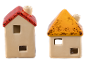 Dois castiçais de cerâmica em forma de casa com telhados vermelhos e amarelos sobre fundo preto.