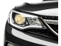Frente de um carro com o farol aceso.