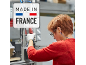 Trabalhadora de fábrica com sinal 'MADE IN FRANCE'.