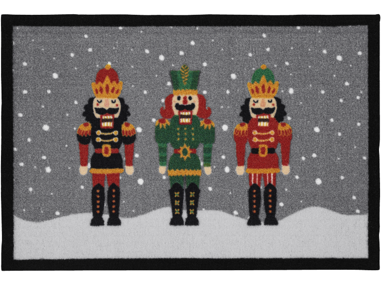 Capacho de Natal com três quebra-nozes coloridos sobre um fundo nevado.