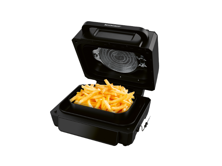 Fritadeira de ar preta com batatas fritas douradas no interior.