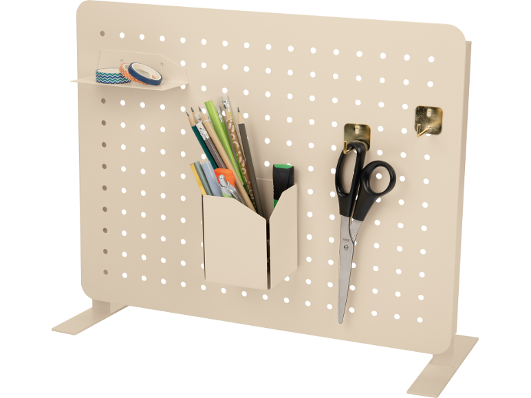 Painel perfurado bege com organizador de canetas, tesoura e fitas decorativas.