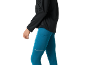 Mulher de casaco preto e leggings de corrida azuis.