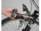 Uma mão usa uma chave de fendas de roquete para ajustar a luz de uma bicicleta.