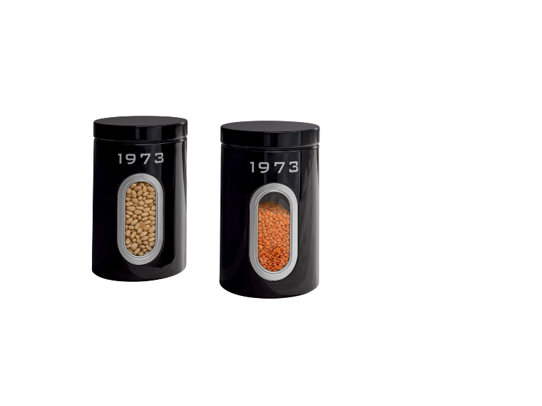 Dois recipientes de armazenamento pretos com o texto '1973', um com feijão e outro com lentilhas.