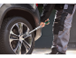 Homem apertando os parafusos da roda do carro com uma chave dinamométrica.