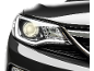 Farol de um carro preto brilhante com as luzes acesas.