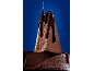 Bolo de chocolate com calda de chocolate derretida sobre fundo azul.