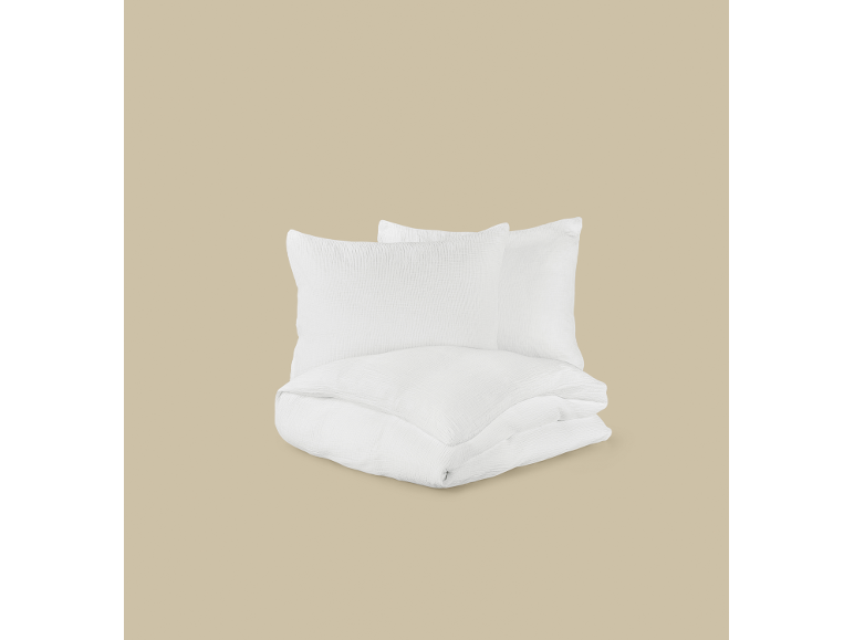 Conjunto de roupa de cama branca com duas almofadas e um edredão dobrado.